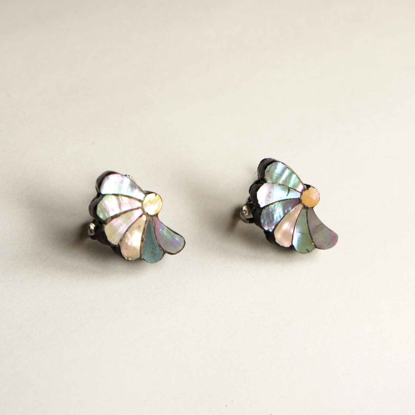 螺鈿耳飾り「晩花、ゆれて」（大）ピアス／イヤリング、菅野かおり作。ねじり菊の半分をデザインにしたピアス。桧を削り出し、花びらアワビの貝を貼った大人可愛いピアス／イヤリング。