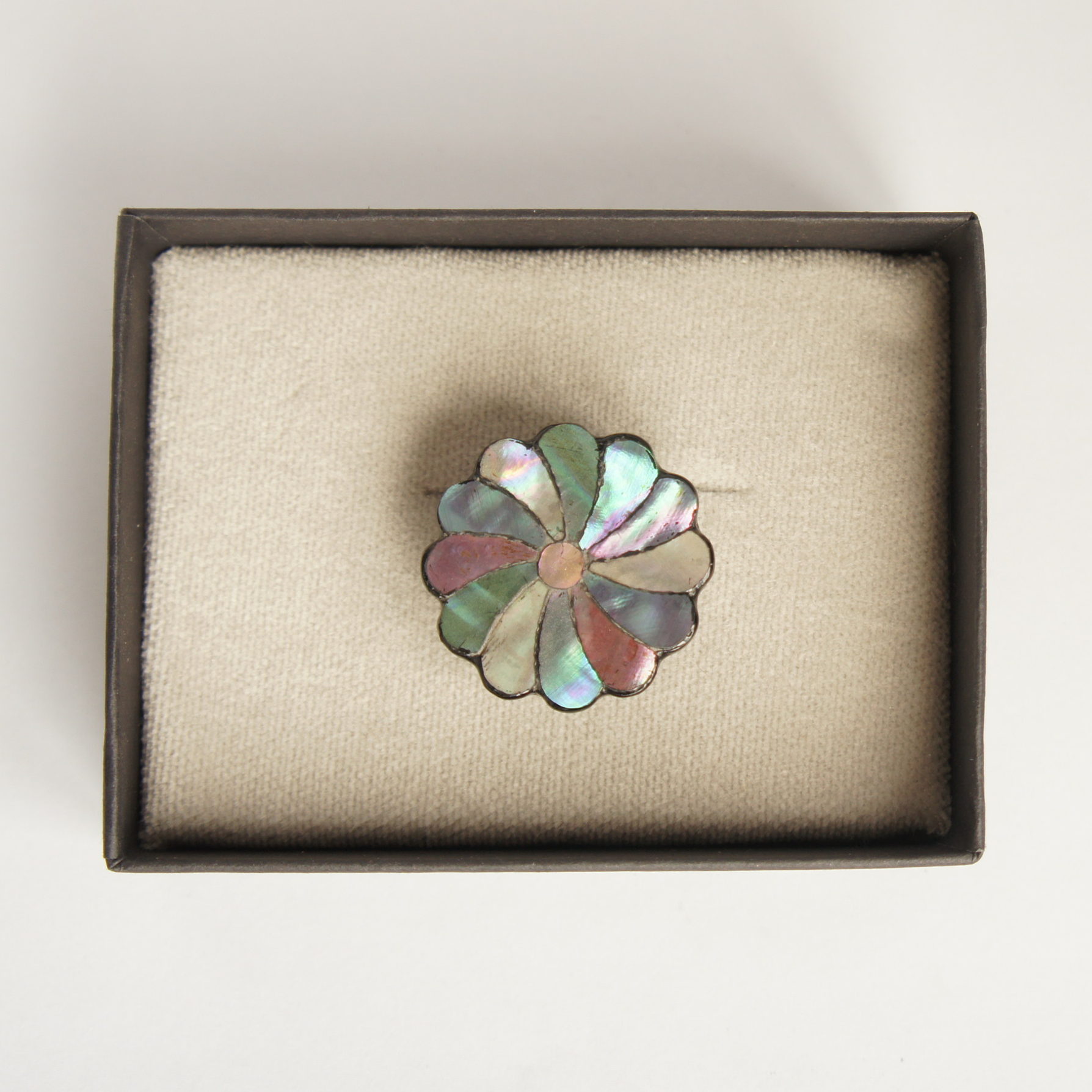 ‘Autumn Bloom', a raden obidome by Kaori Sugano. A contemporary reinterpretation of the traditional twisted chrysanthemum motif. A piece of cypress wood has been carved into the silhouette of a chrysanthemum flower, approximately 3 centimetres in diameter, with natural mother-of-pearl in varying shades arranged petal by petal. Each piece has been meticulously crafted using traditional lacquer techniques.