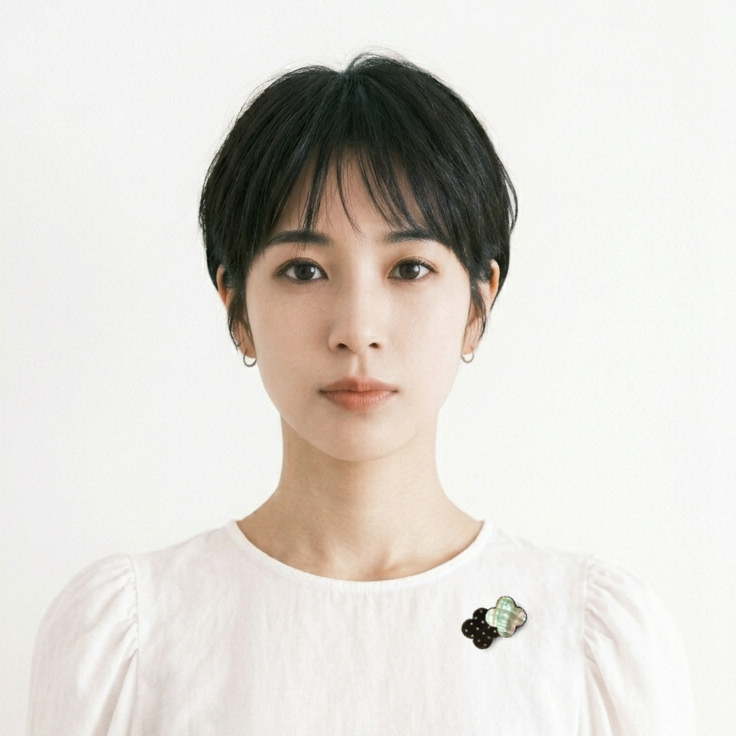 螺鈿ブローチ「花あそび」菅野かおり作。二つの連なった花のフォルムの片側全体をアワビ貝、もう片側は黒漆を背景に螺鈿のドット文様。大人可愛い漆塗りのブローチ。着用イメージ。